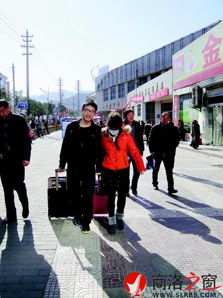 一對(duì)情侶模樣的人，一人拖一個(gè)拉桿箱