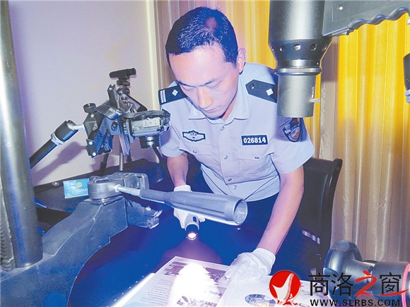 楊飛在實驗室對案件現(xiàn)場的物證提取指紋